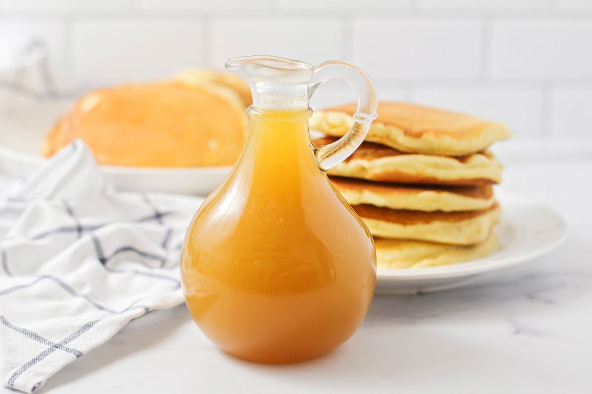 Bottle of buttermilk syrup in front of pancakes.