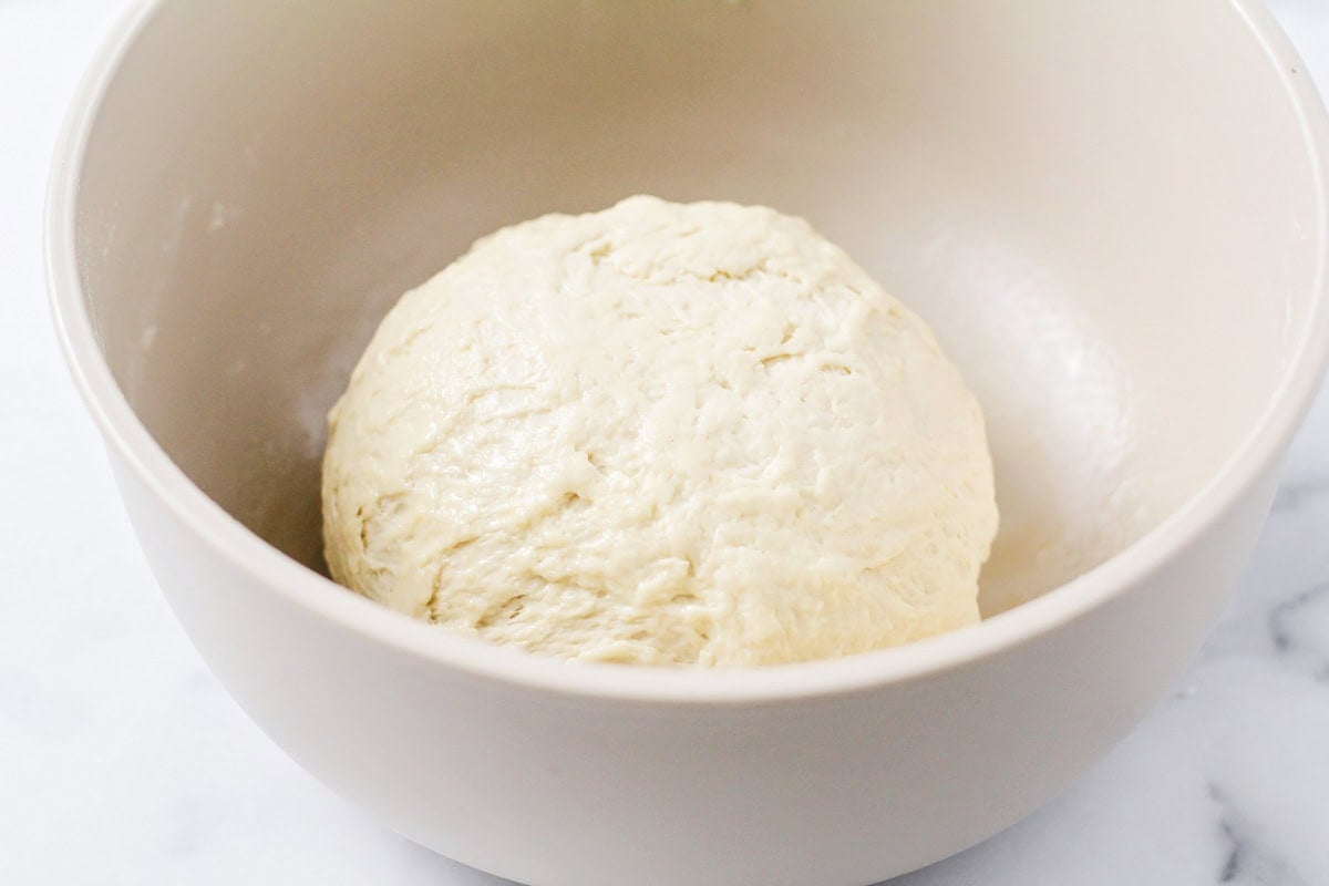 Homemade calzone recipe dough in mixing bowl.