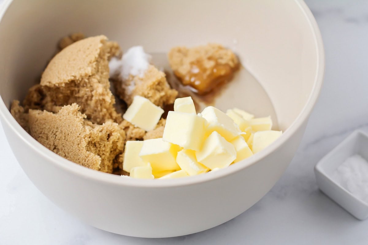 Ingredients for homemade caramel popcorn added to a mixing bowl.