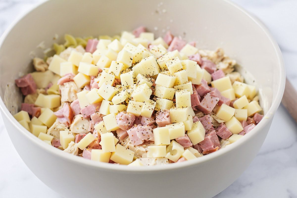 A bowl of cubed cheese and ham with other seasonings.