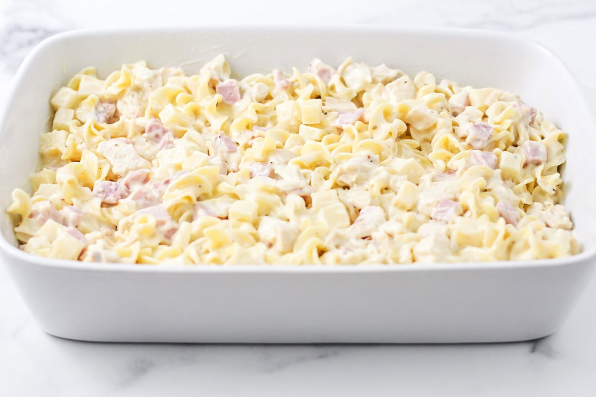 Pasta and cheese mixture spread in a baking dish.