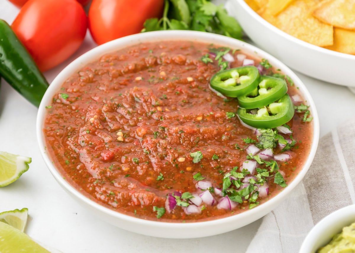 Chili's salsa served in a white bowl topped with fresh jalapenos.