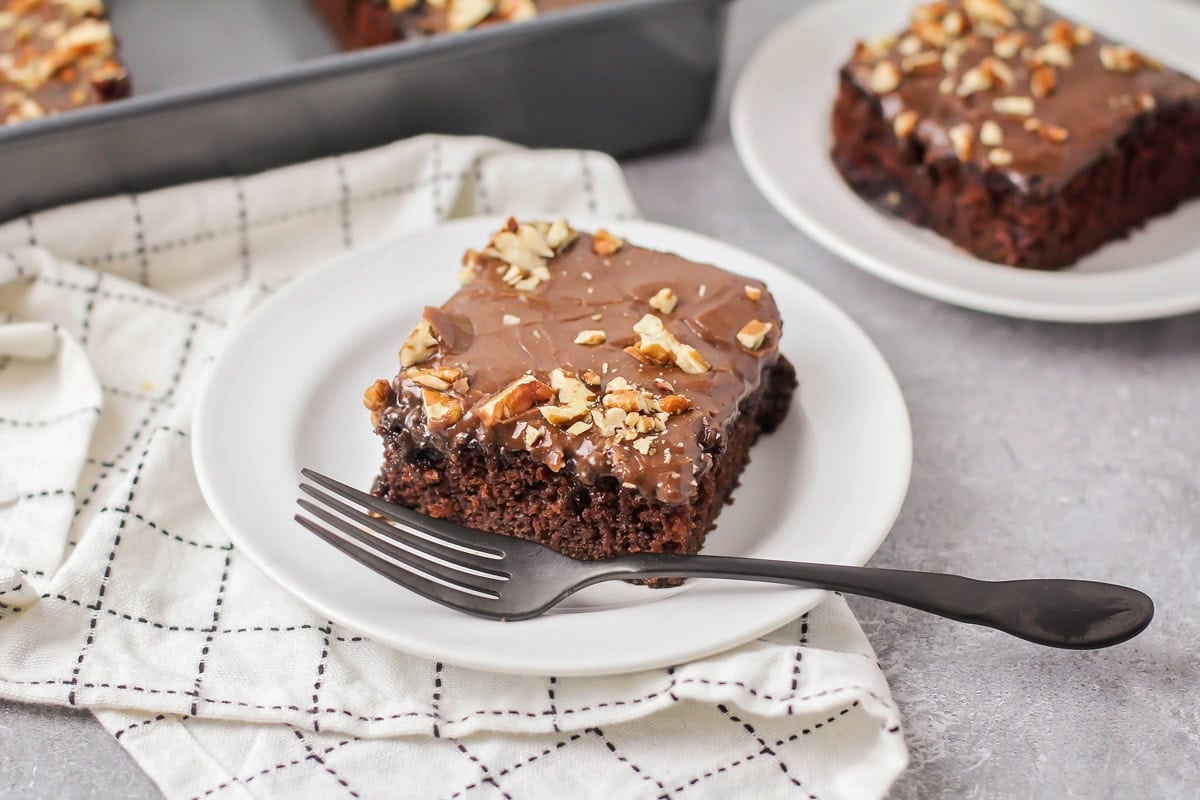 A slice of chocolate sheet cake served on a white plate.