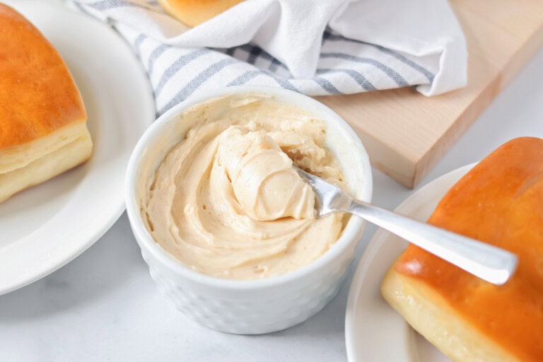 Cinnamon butter in small, white bowl with butter on knife.