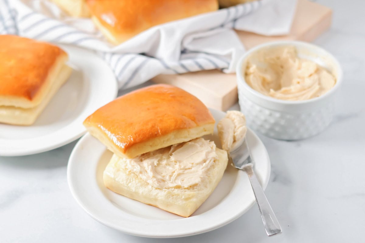 Sweet and fluffy cinnamon butter is whipped to perfection with 4 ingredients and 5 minutes, it's even better than Texas Roadhouse!! Homemade cinnamon butter spread on a warm roll.