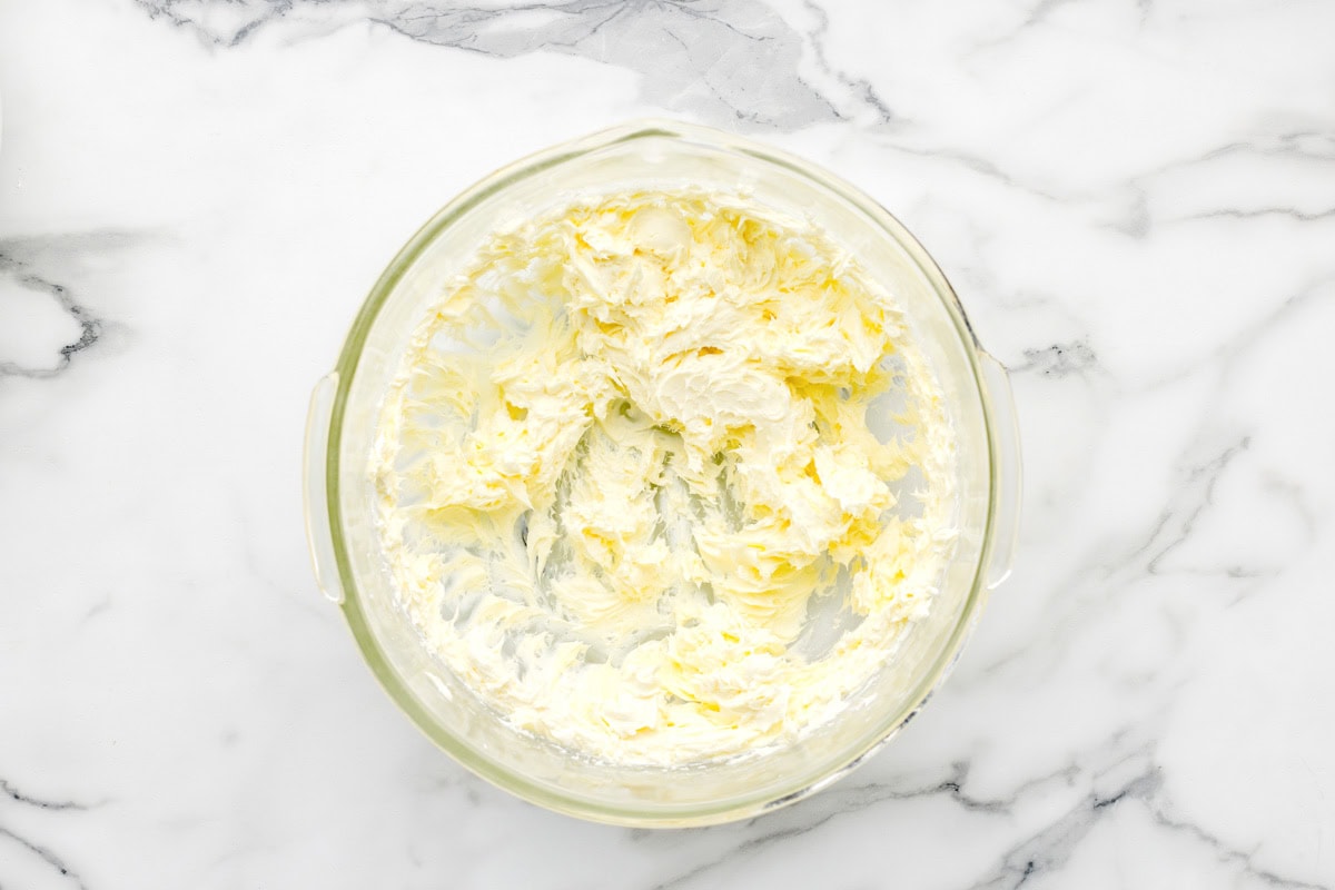 Butter and cream cheese creamed together in glass bowl.