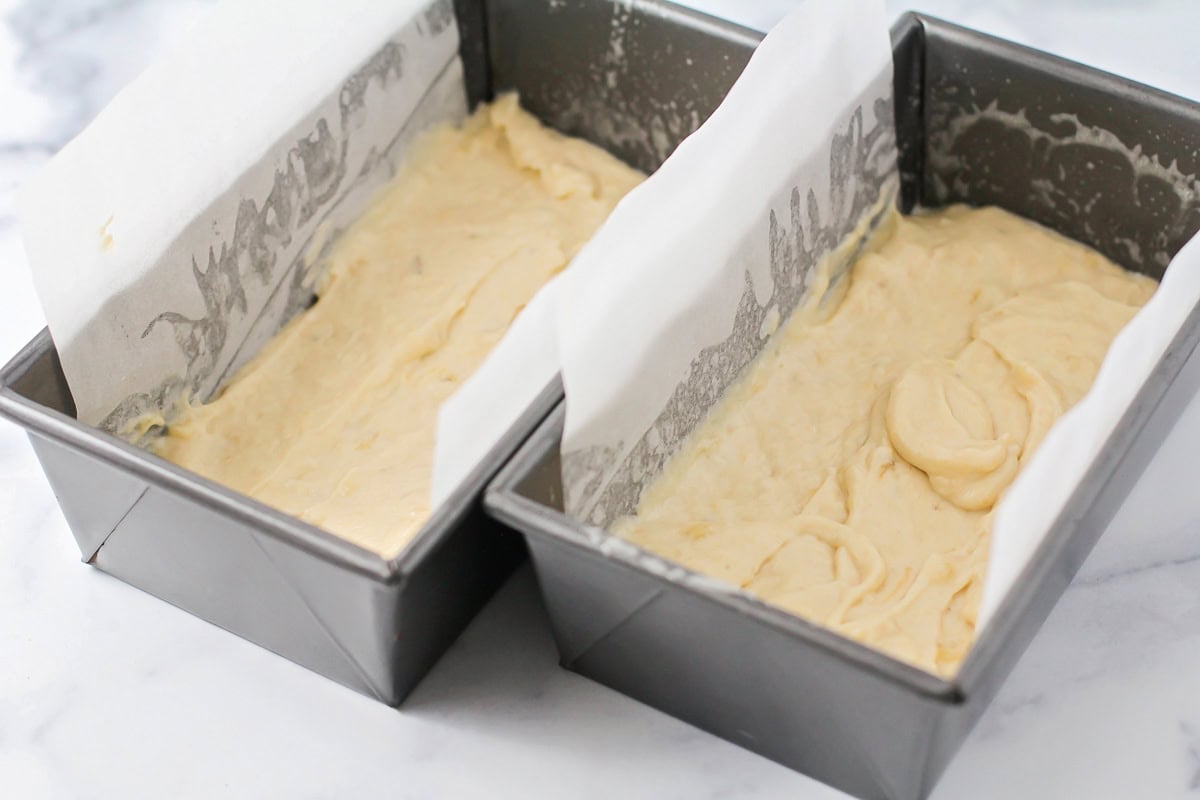 Two lined bread pans filled with batter.