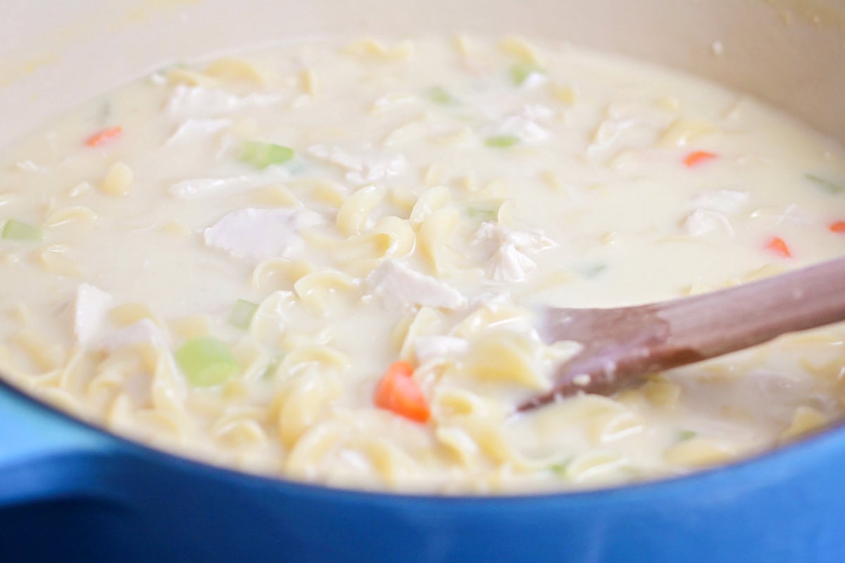 Stirring chicken soup in a dutch oven.