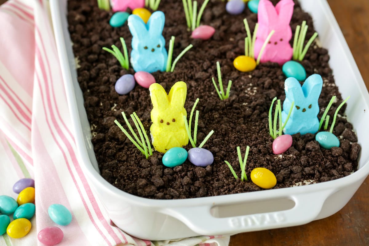 No-bake Easter dirt cake is a super simple creamy favorite packed with Oreo flavor. Everyone will love to decorate and eat it! Close up of Easter dirt cake topped with Oreo and peeps.