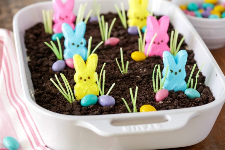 Easter Dirt Cake with Easter candies and edible grass in white dish.