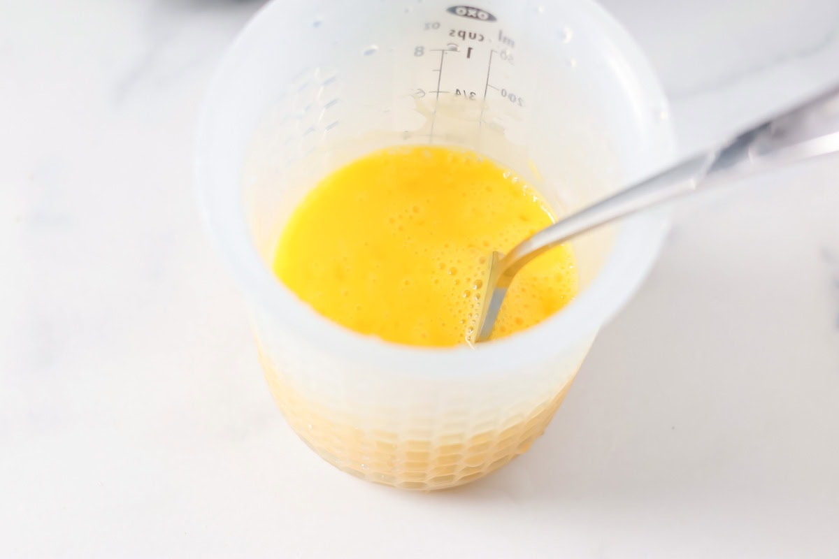 Whisked egg yolks and egg whites in a measuring cup.