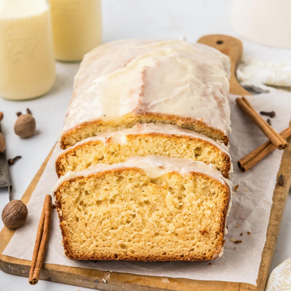 Slices of eggnog bread on parchment paper on cutting board.