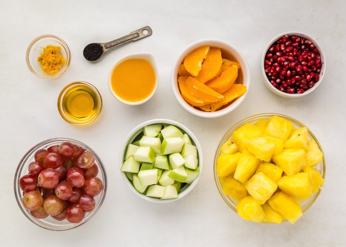 Ingredients for fall fruit salad on a white countertop.