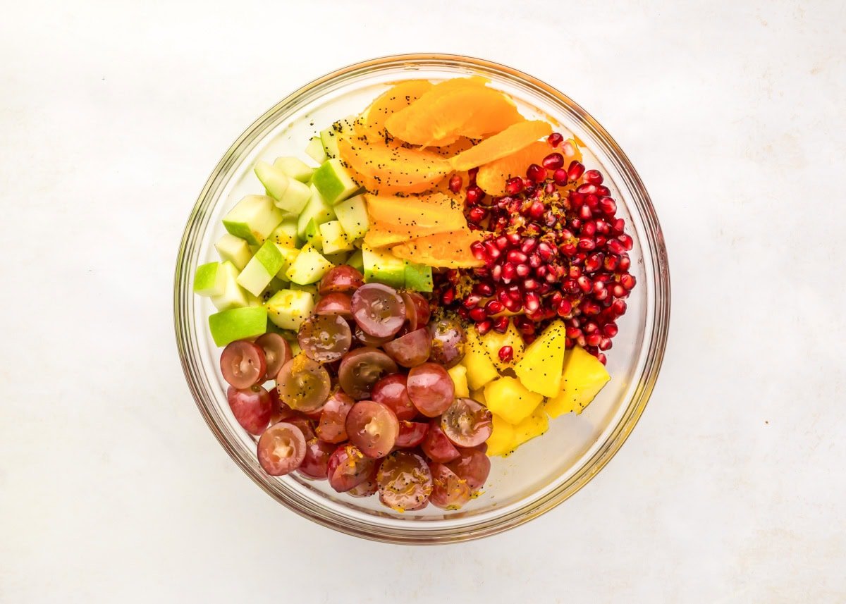 Fruit for fall fruit salad added to a glass mixing bowl.