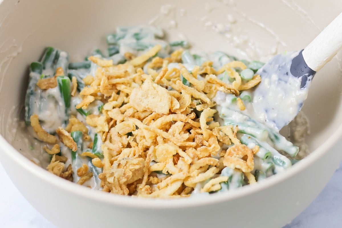 Adding fried onions to green bean mixture.