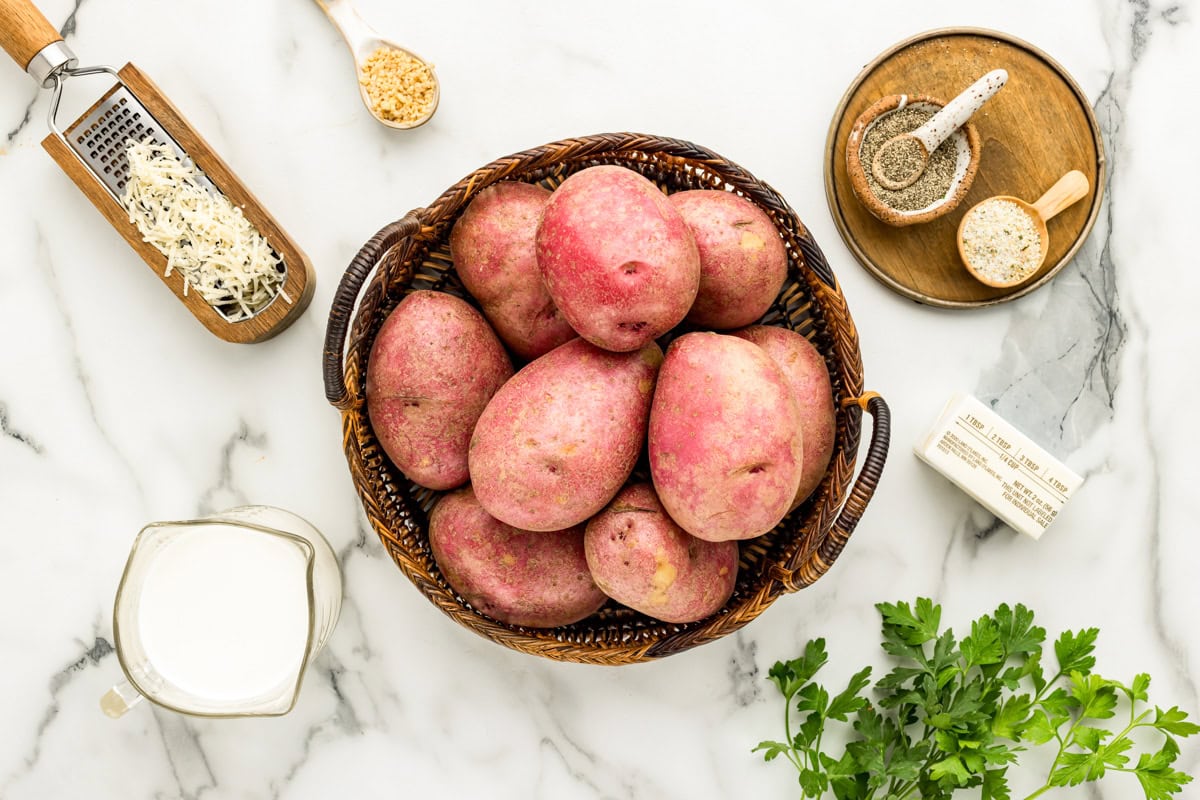 Ingredients for garlic red mashed potatoes on a marble countertop.