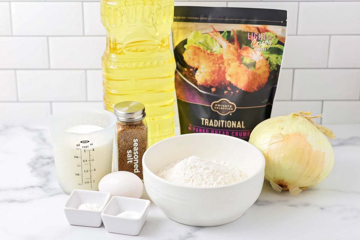 Lightly breaded and extra crispy, our onion rings are just the way we like them - and they're ready in only 30 minutes! Onion, panko bread crumbs, and other ingredients on a kitchen counter.