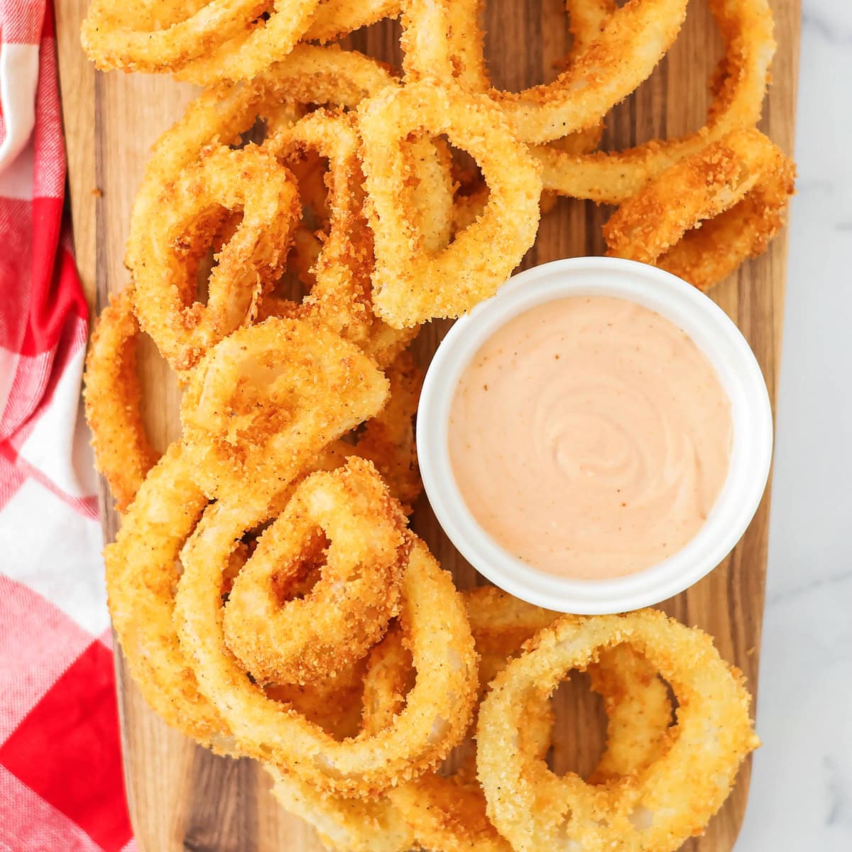 A platter of onion rings served with fry sauce.
