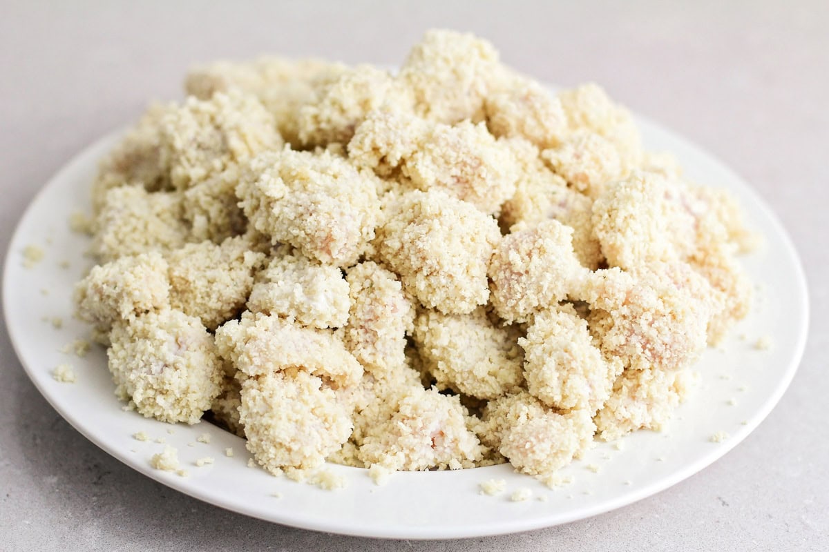 Breaded chicken pieces on a white plate.