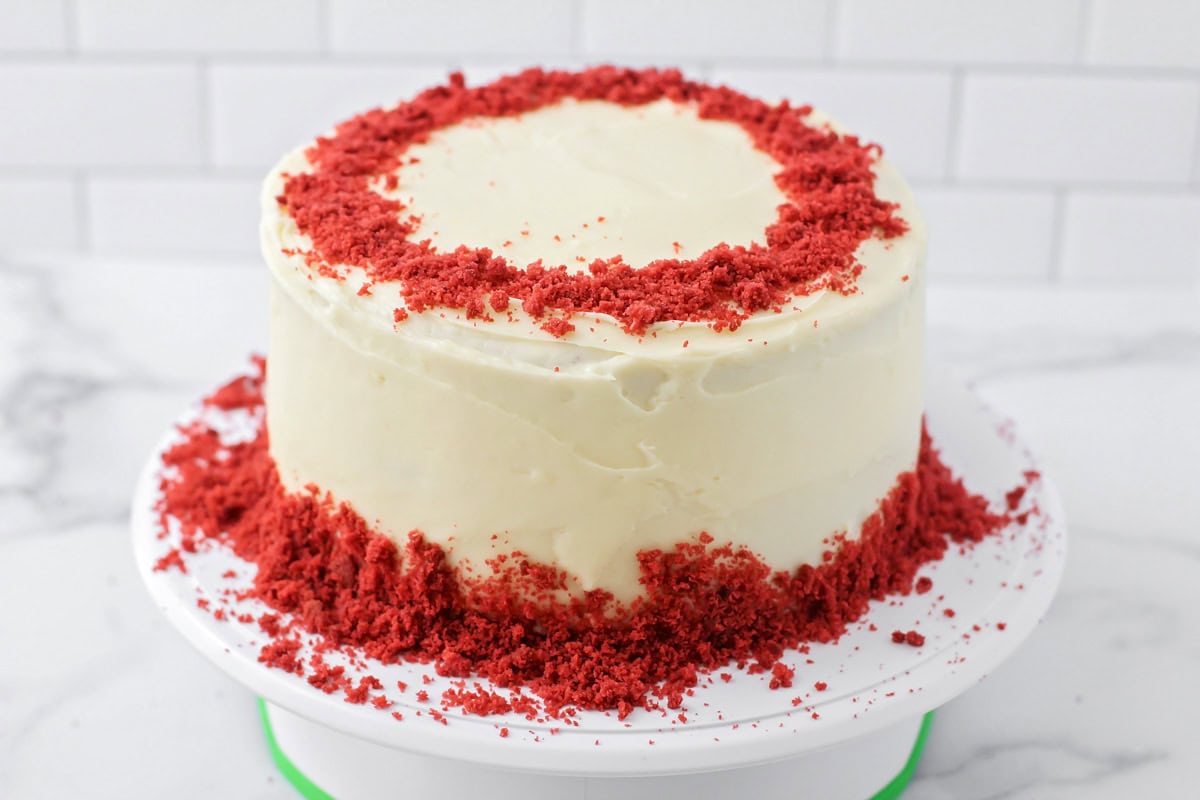 A frosted red velvet cake on a cake platter.