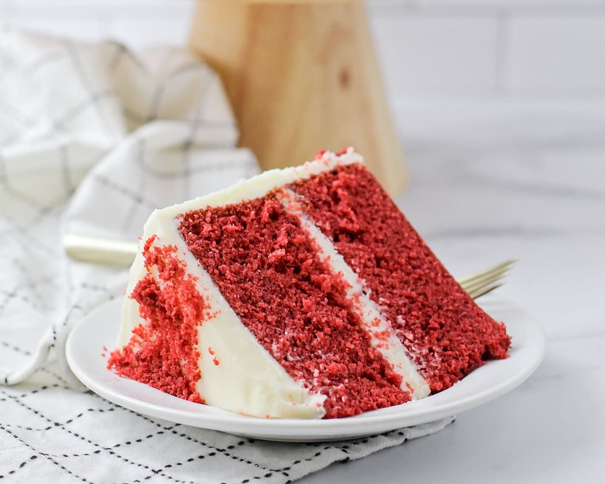 A slice of red velvet cake on a white plate.