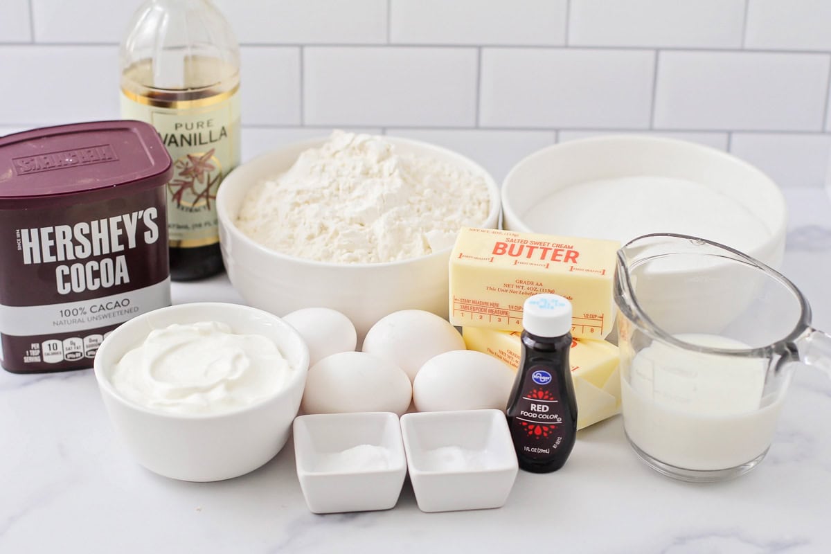 Vanilla, flour, sugar, butter, cocoa, and other ingredients on a kitchen counter.