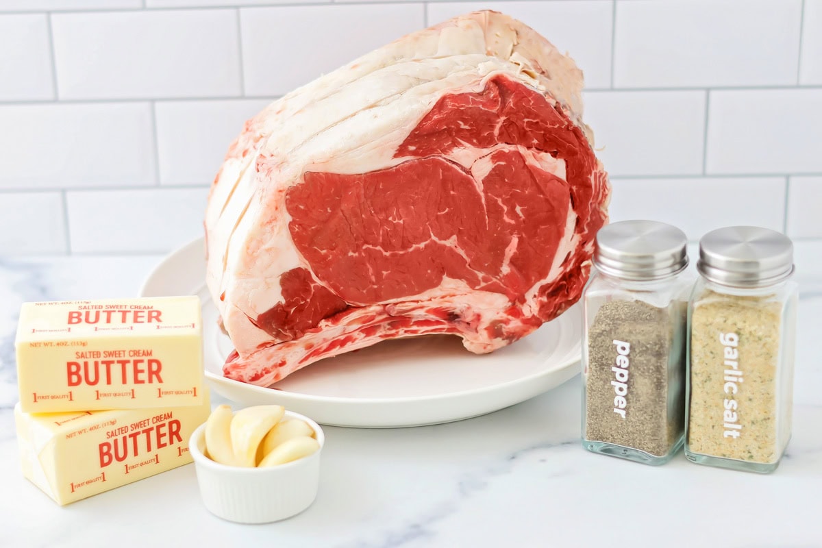 A rib eye roast, butter, and seasonings, on  kitchen counter.