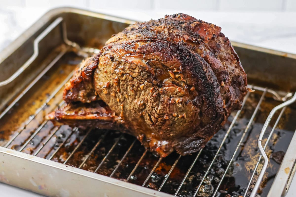 A cooked rib eye roast on a baking pan.