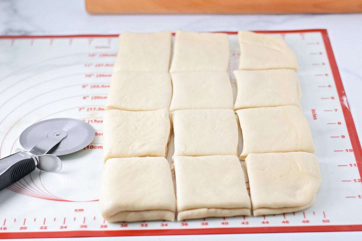 Dough for rolls cut into small squares on a silpat mat.