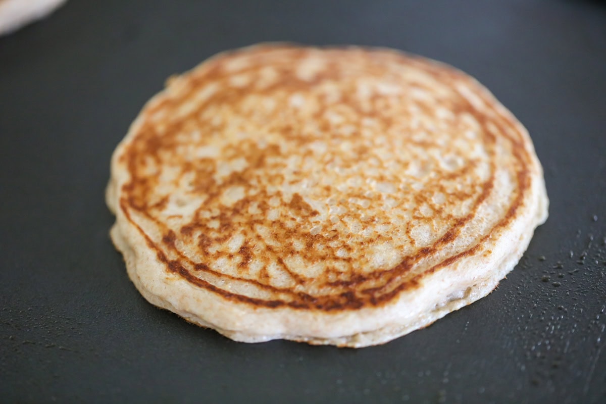 A pancake cookie on a griddle.