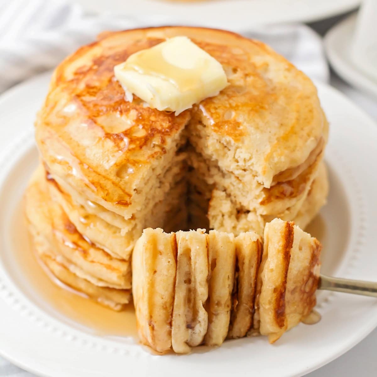 A stack of whole wheat pancakes with a bite missing.