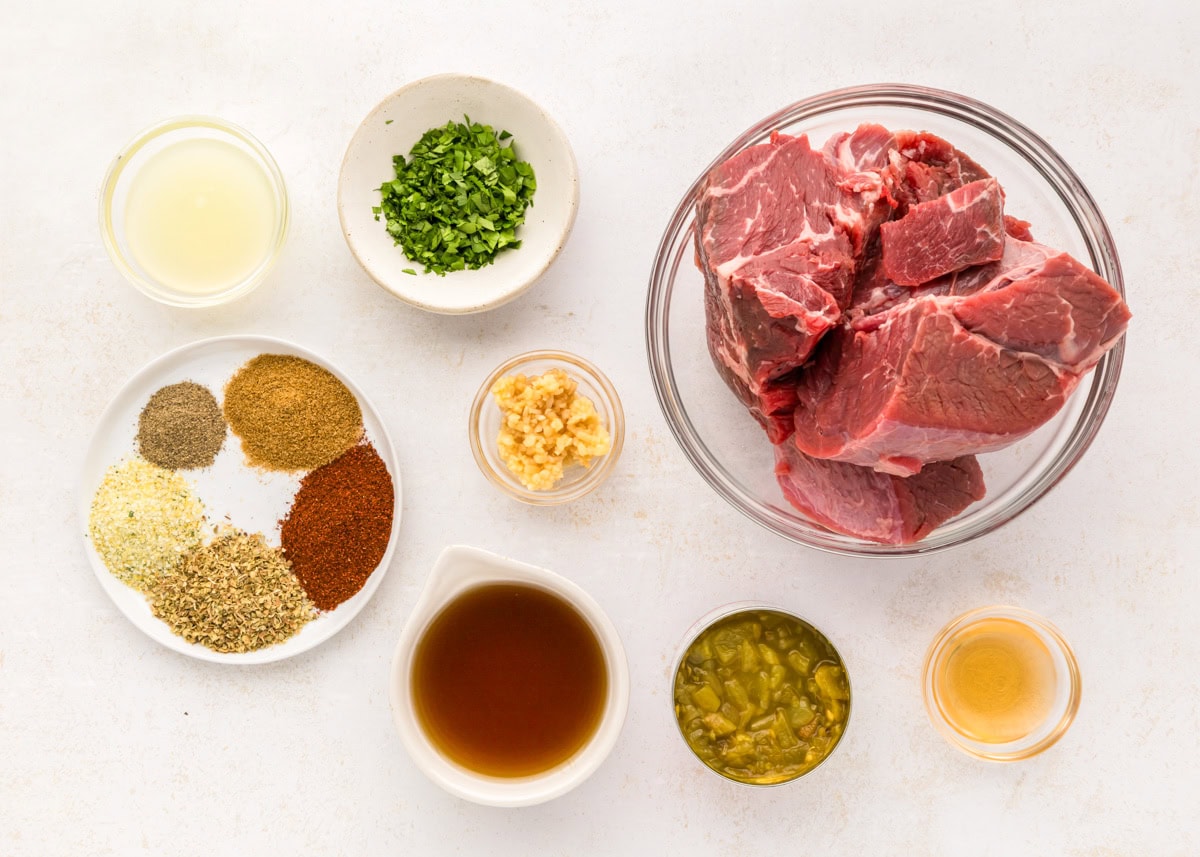 Ingredients for barbacoa on a white kitchen counter.