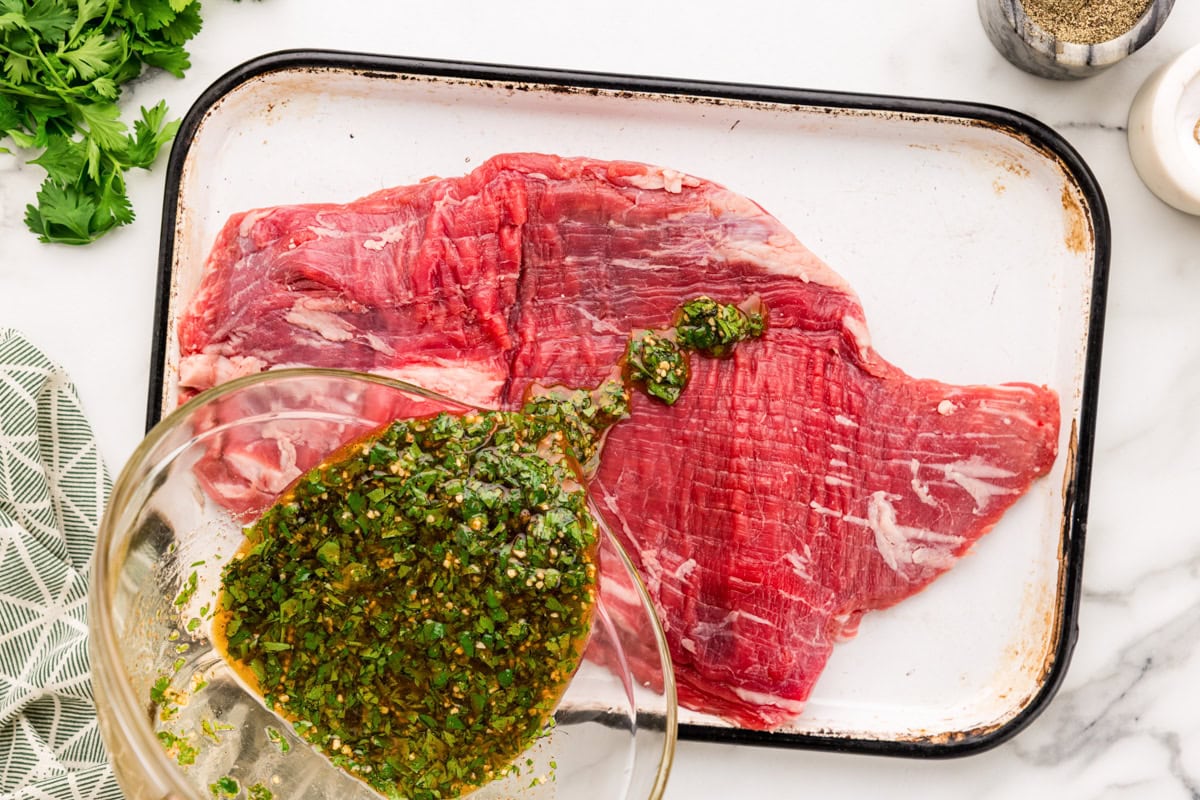 Pouring the marinade over the steak.