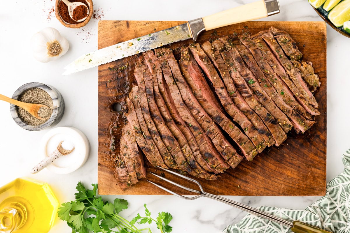 Slicing steak on a wooden cutting board.