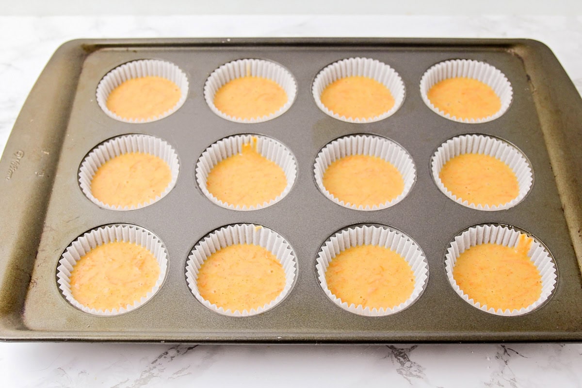 Carrot cake cupcake batter poured into cupcake liners.