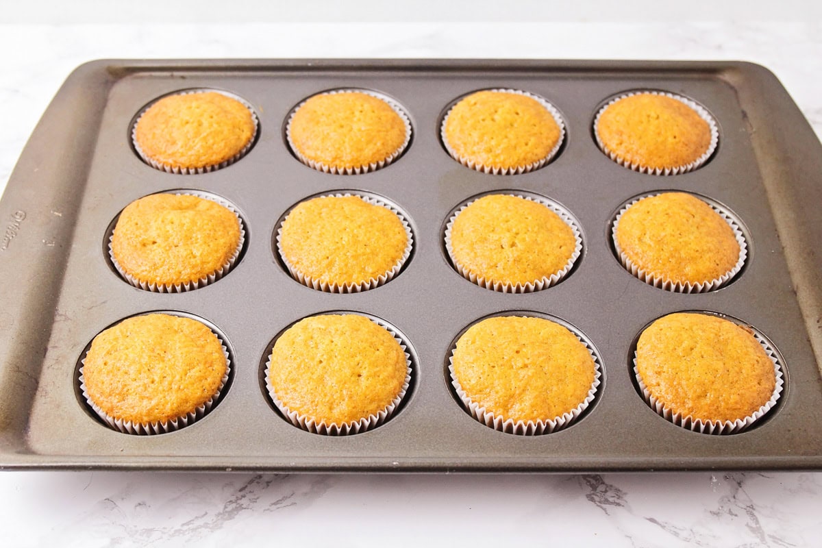 Carrot cake cupcakes baked in liners in mufifn pan.