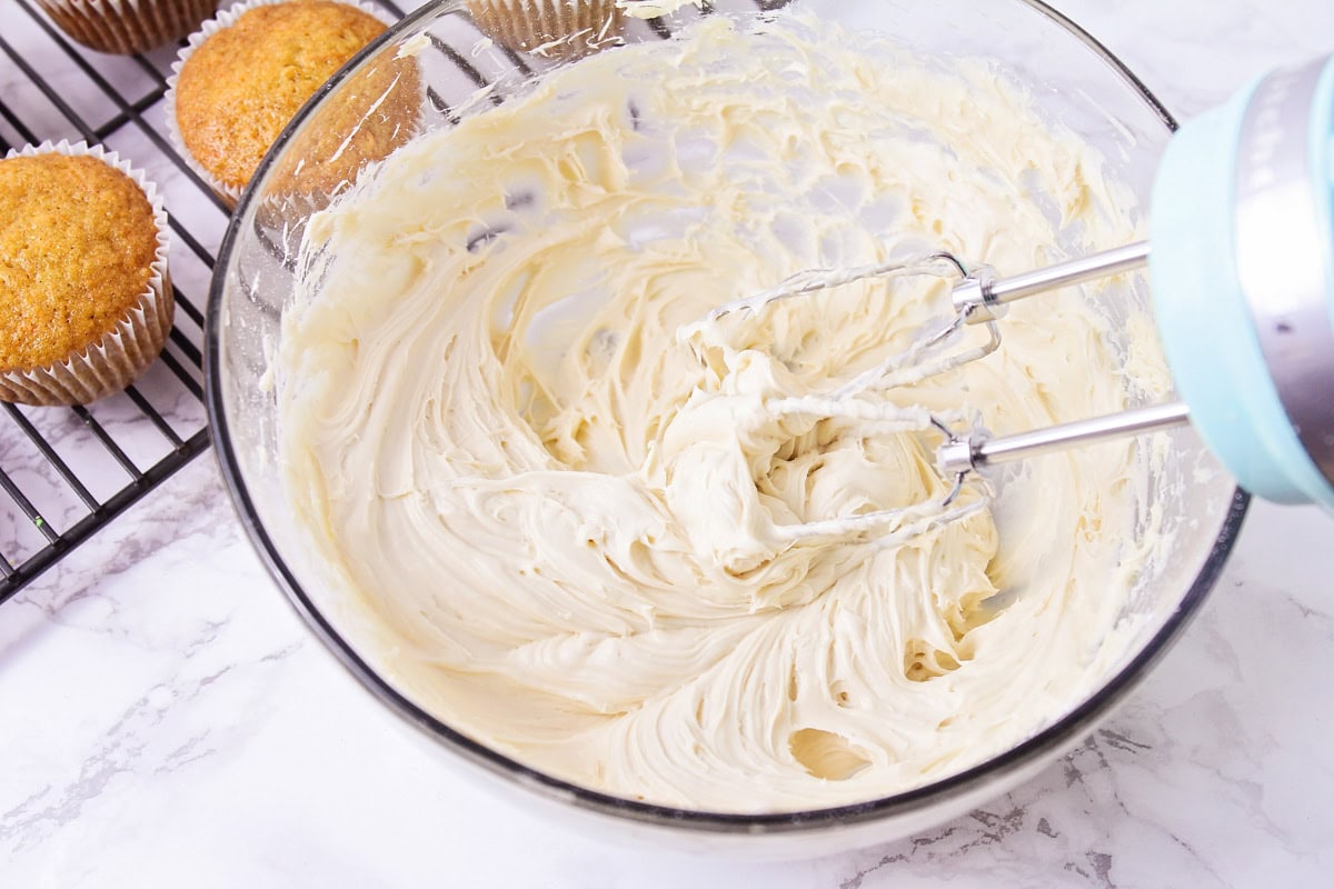 Brown sugar cream cheese frosting mixed together in glass bowl.