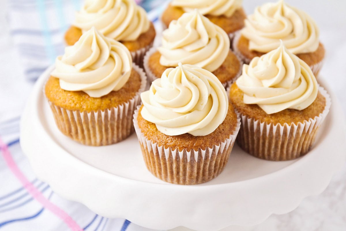 Carrot cake cupcakes on white cake stand.