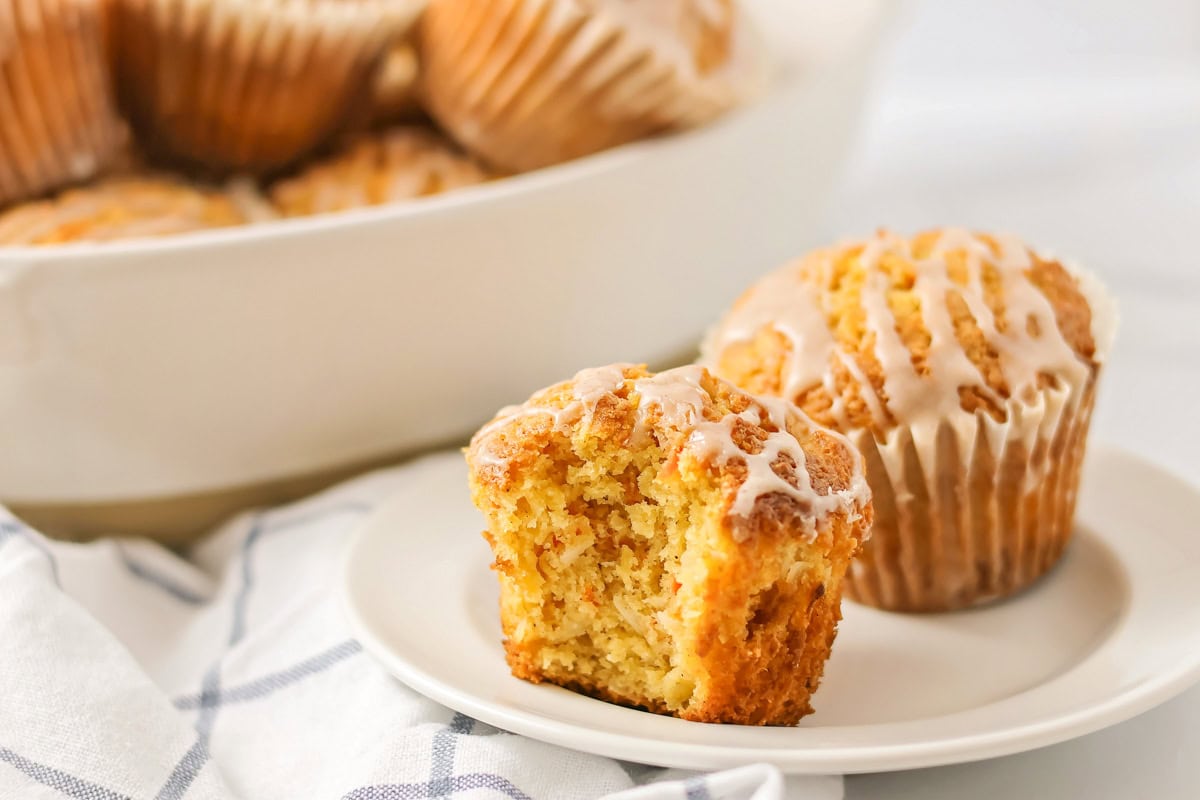 Carrot cake muffins on plate with bite taken out.