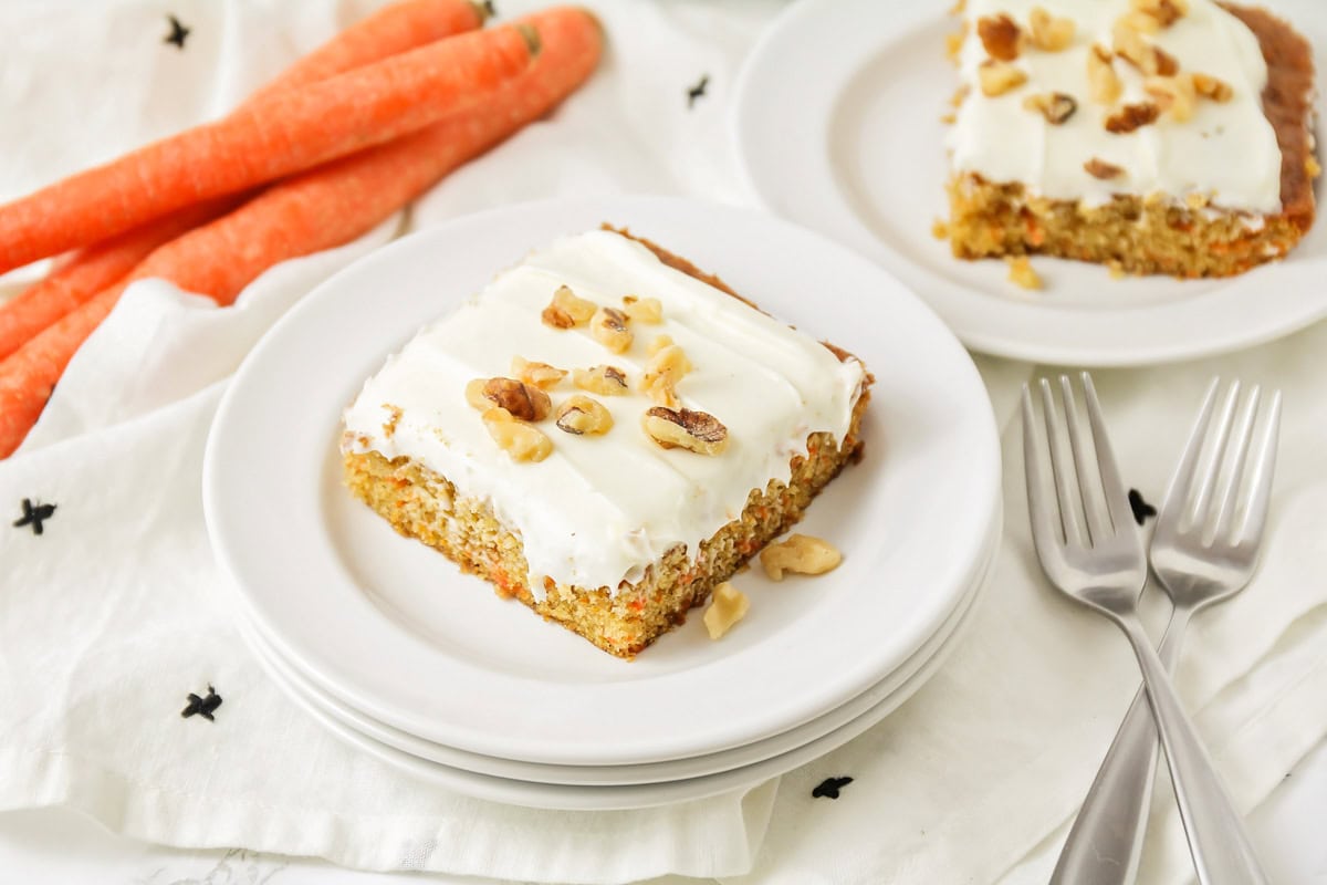 Carrot sheet cake slice on white plates.