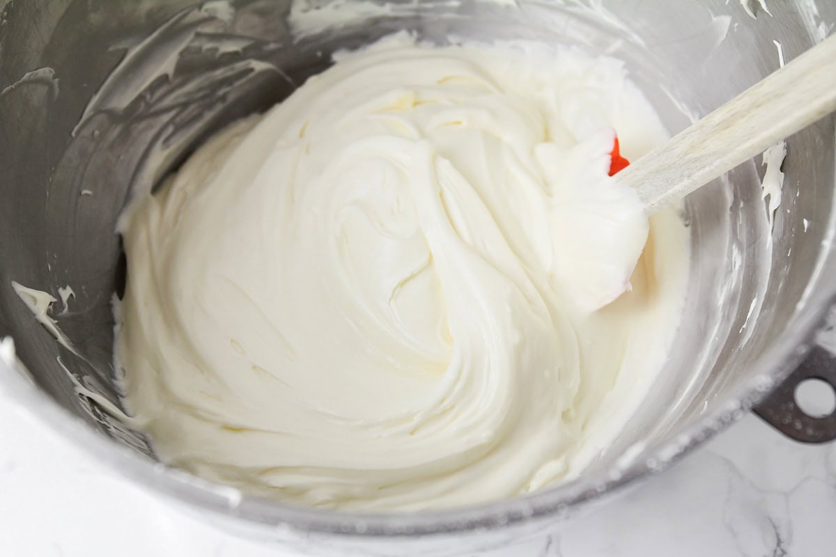 Cream cheese frosting for carrot sheet cake whipped in a mixing bowl.