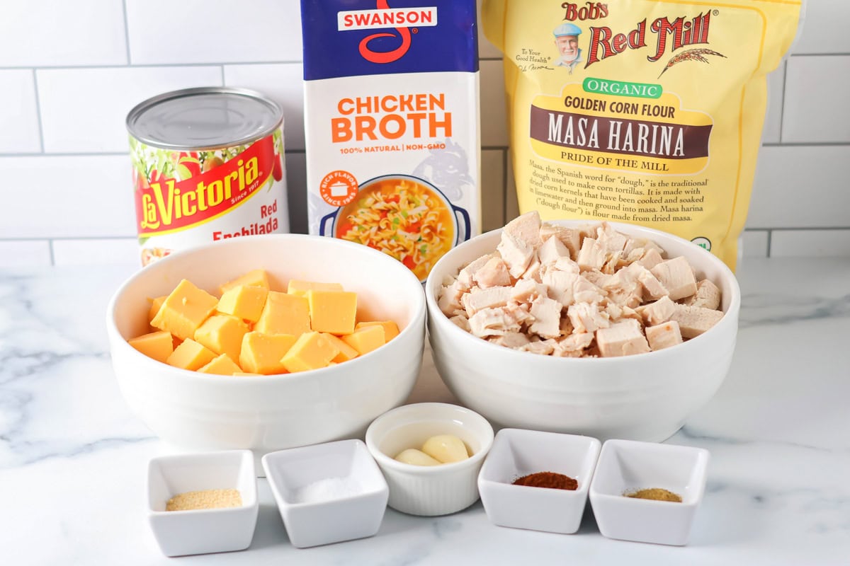Thick and cheesy Chili's chicken enchilada soup tastes just the original! With mostly shelf-stable ingredients it's our favorite go-to soup. Masa harina, chicken, velveeta, and other ingredients on a kitchen counter.
