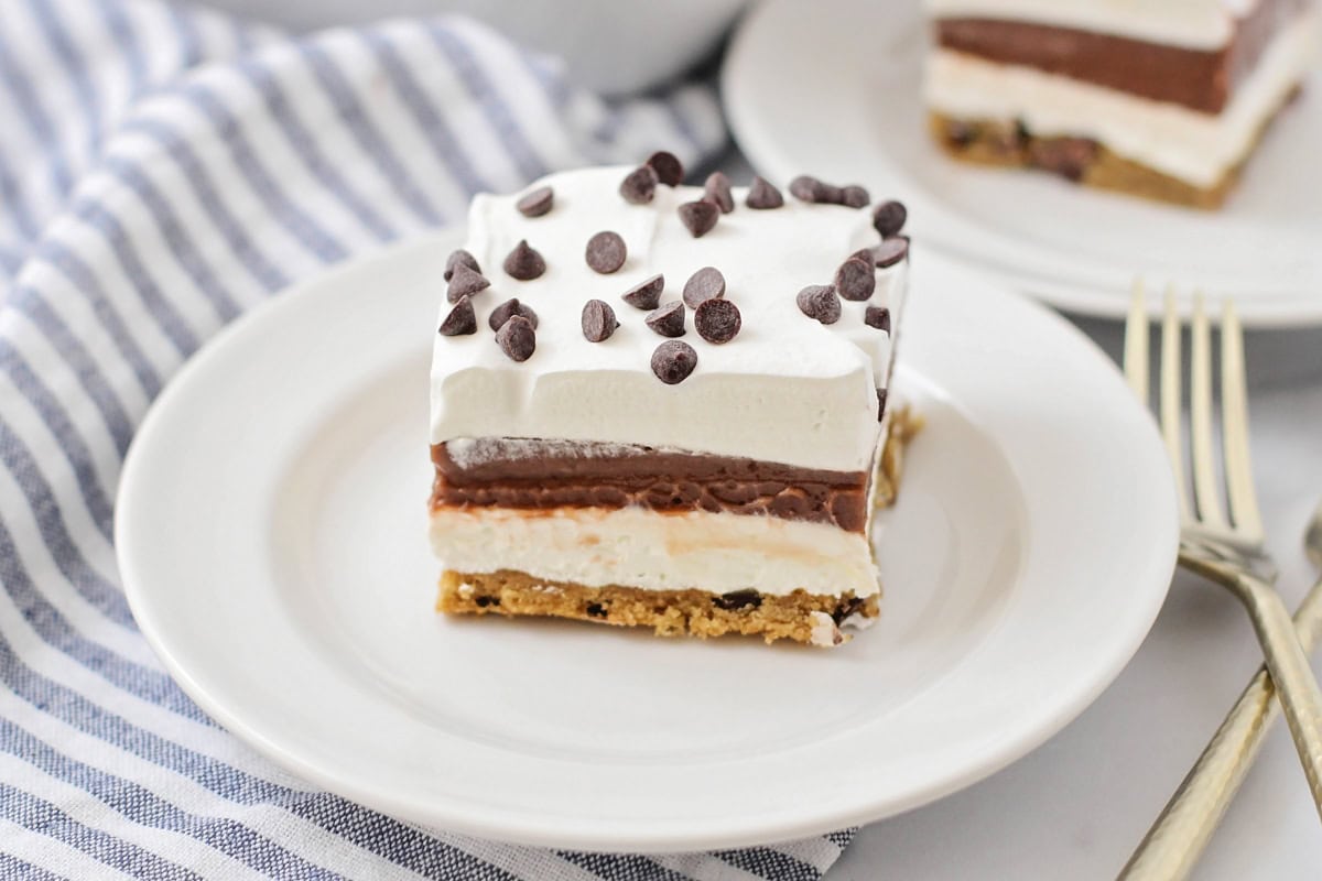 A square slice of chocolate delight recipe on a white plate.