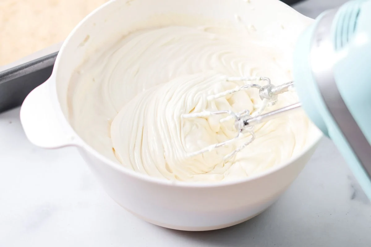 Whipping cream cheese mixture in a white bowl.