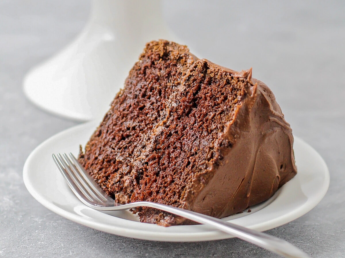 Slice of Hershey's chocolate cake recipe on white plate.