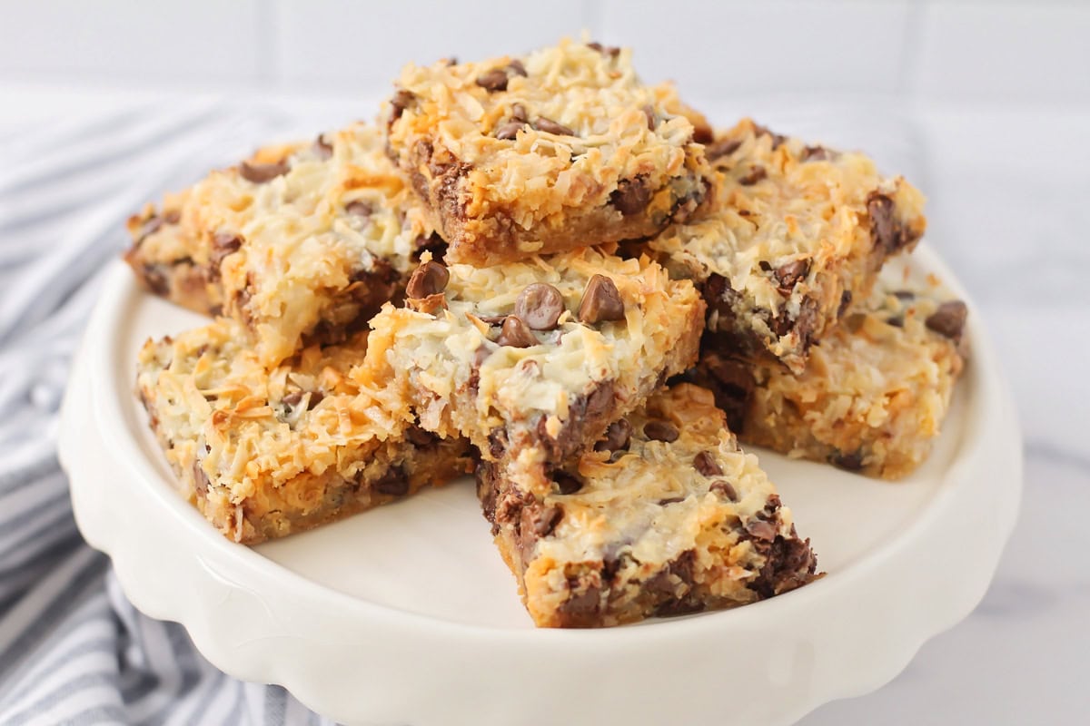 A white platter topped with magic cookie bars cut into squares.