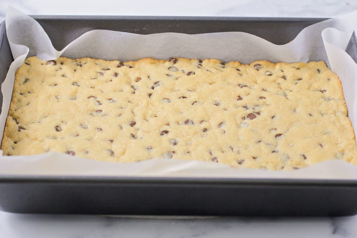 Baked cookie layer in a lined pan.