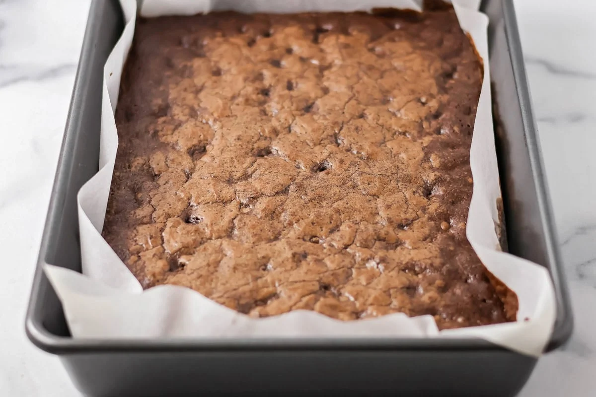 Cooked brownies in a lined baking dish.