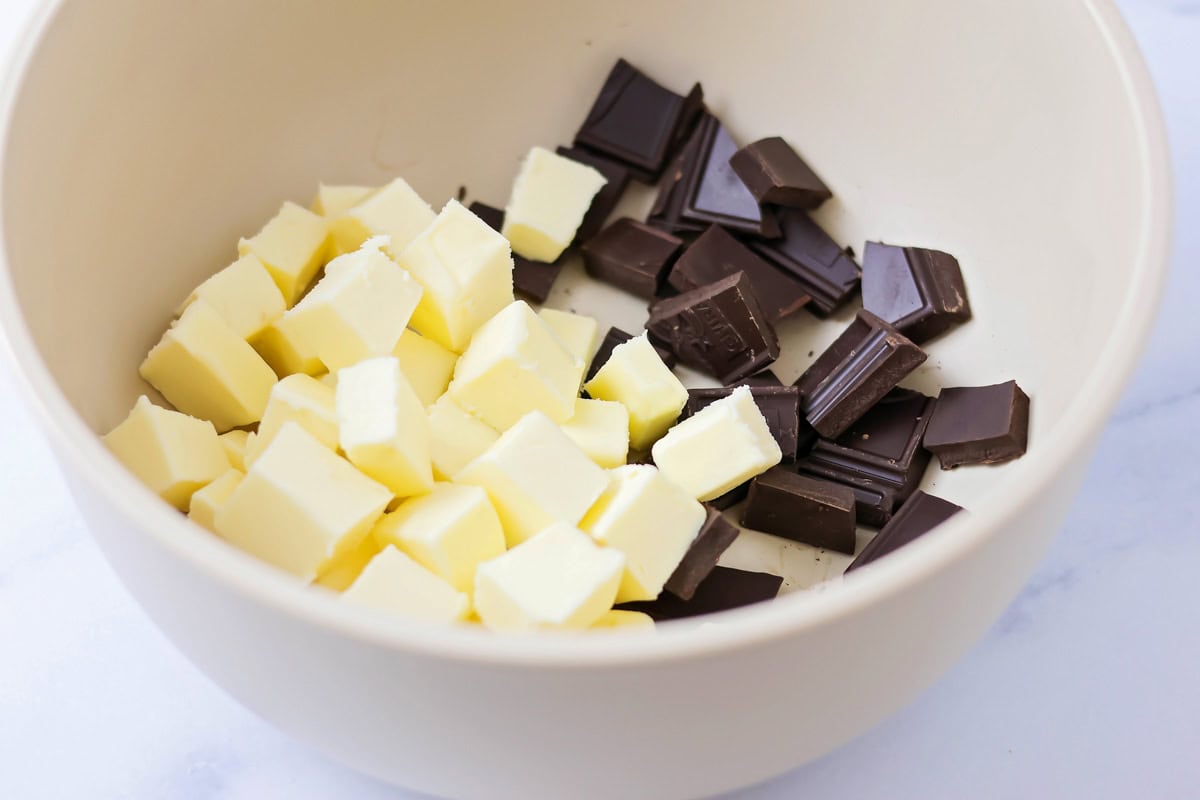 Cubed butter and chocolate in a white bowl.