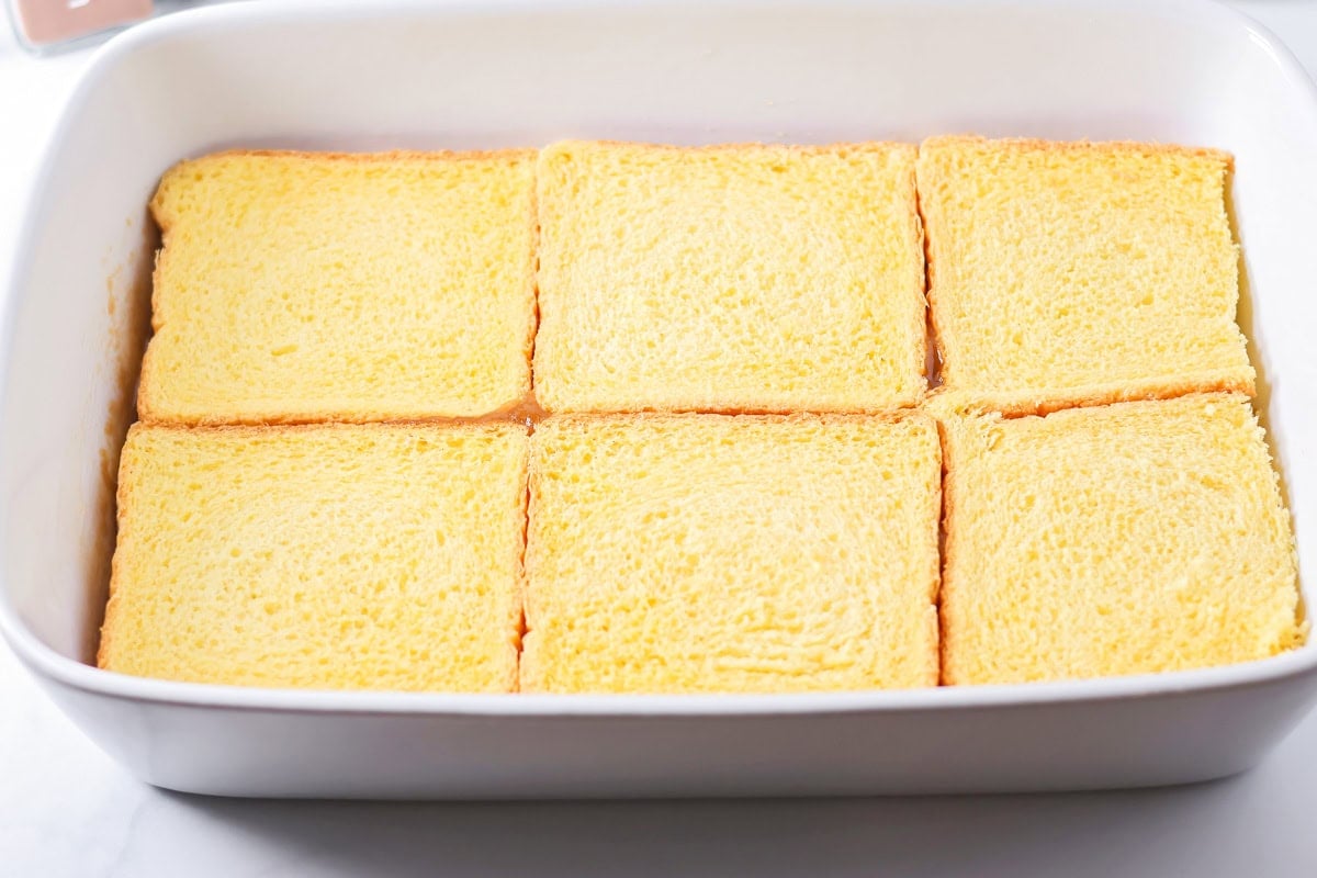 Layering Texas toast on top of brown sugar mixture.